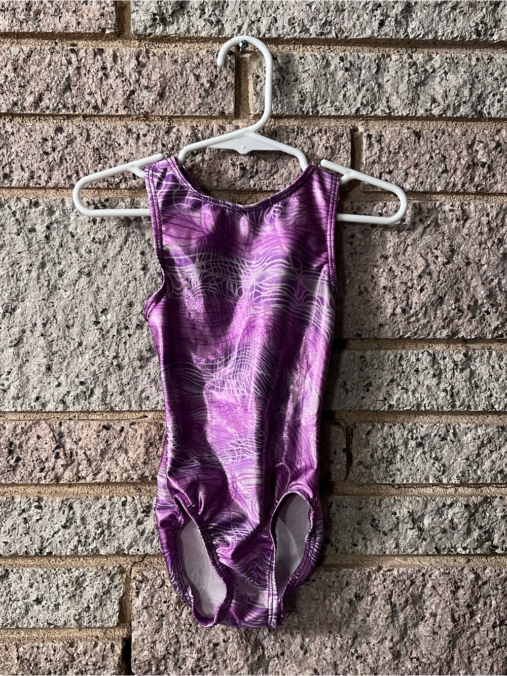 Purple shimmery XXS gymnastic leotard or swimsuit for baby’s first lessons.